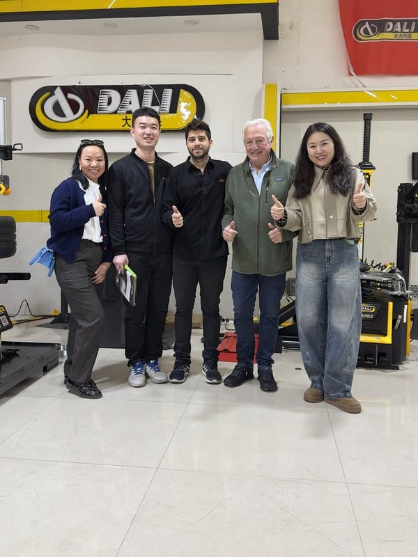 Equipo de Ewing junto a representantes de un fabricante de equipamiento para talleres, en el showroom de la fábrica.