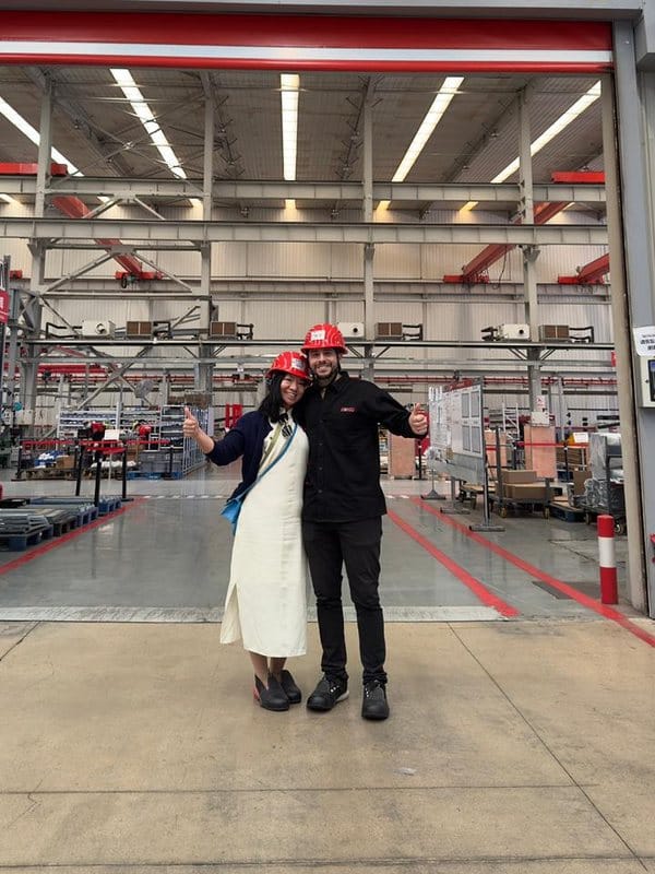 Recorrida por la planta de un proveedor, con casco de seguridad, frente a la nave de producción.